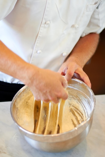 Ga niet te ver Shot van een bakker die deeg kneedt in een kom