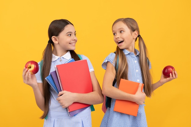 Ga weer gezond naar school Gelukkige kinderen houden boeken en appels vast Gezond eten Schoolvoeding Voedseleducatie Voedzaam dieet Maak fruit verplicht