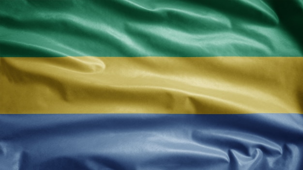 Photo gabonese flag waving in the wind. close up of gabon banner blowing, soft and smooth silk