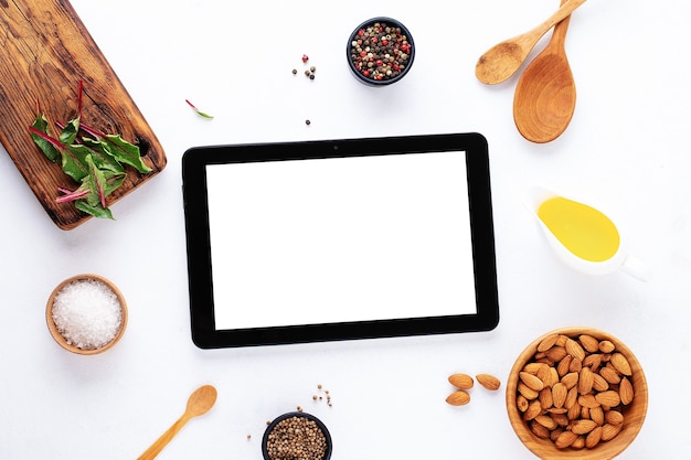 Gadget mockup blank text space on white background with  spices, oil, board, salt and nut . Food blog recipe cookbook or delivery app with cooking ingredient.