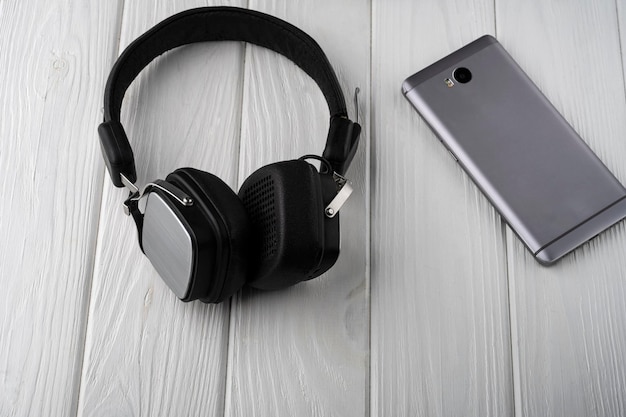 Gadgets on the table. phone, headphones and fitness tracker on\
the table