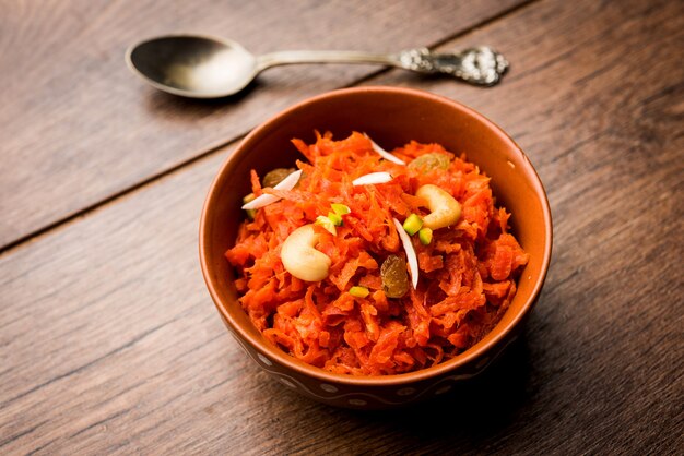 Gajar ka halwa is a carrot-based sweet dessert pudding from India. Garnished with Cashew almond nuts. served in a bowl.