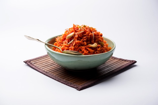 Gajar ka halwa is een zoete dessertpudding op basis van wortel uit India. Gegarneerd met cashew amandelnoten. geserveerd in een kom.