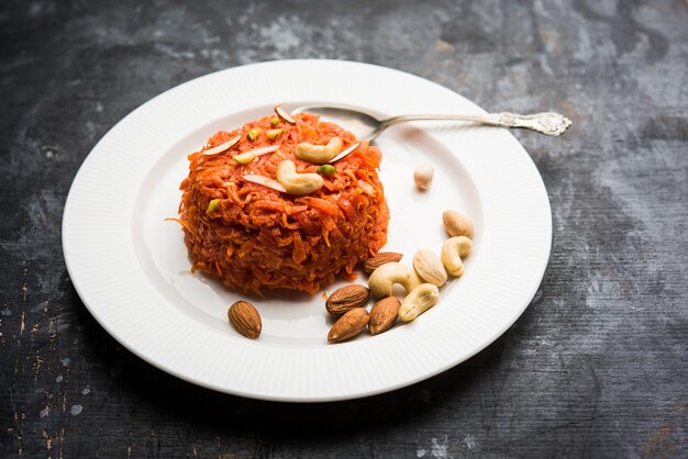 Gajar ka halwa is een zoete dessertpudding op basis van wortel uit India. Gegarneerd met cashew amandelnoten. geserveerd in een kom.