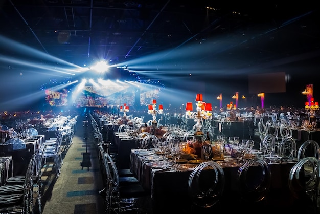 Gala dinner event dinner decor in dark room with stage lights and smoke