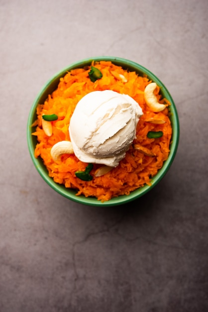 Galar Halwa met vanille-ijs, geserveerd in een kom en gegarneerd met droog fruit. selectieve focus