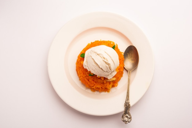 Galar Halwa met vanille-ijs, geserveerd in een kom en gegarneerd met droog fruit. selectieve focus