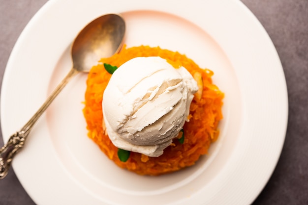 Galar Halwa met vanille-ijs, geserveerd in een kom en gegarneerd met droog fruit. selectieve focus