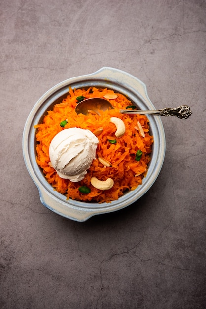 Galar Halwa with Vanilla Ice cream, served in a bowl and garnished with dry fruits. selective focus