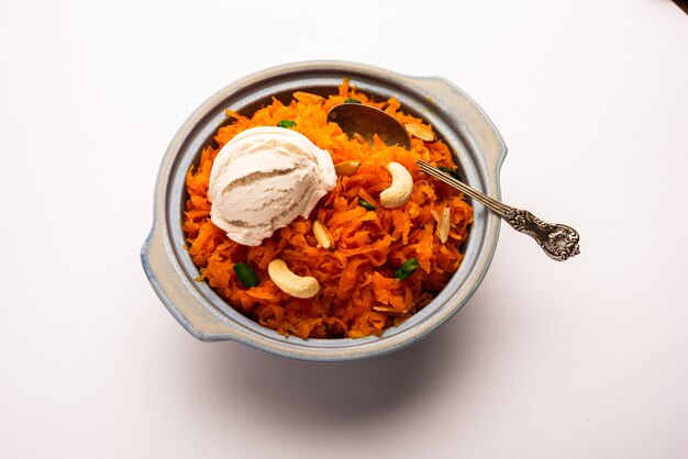Galar Halwa with Vanilla Ice cream, served in a bowl and garnished with dry fruits. selective focus