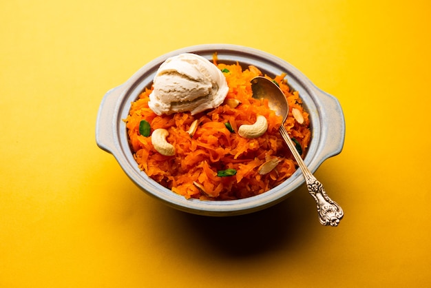 Photo galar halwa with vanilla ice cream, served in a bowl and garnished with dry fruits. selective focus