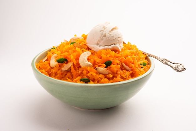 Galar Halwa with Vanilla Ice cream, served in a bowl and garnished with dry fruits. selective focus