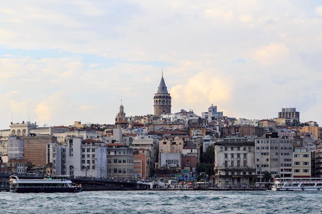 Galata toren te midden van gebouwen voor de zee tegen een bewolkte hemel