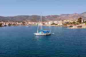 Photo galaxidi greece sailboat anchored traditional waterfront houses background