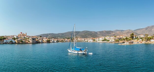 Photo galaxidi greece sailboat anchored traditional waterfront houses background