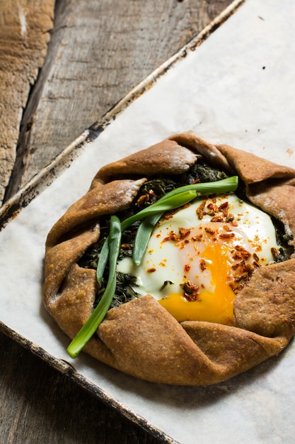 galette tart, tomatoes, pepper, spinach, feta, cheese, tofu. open pie, process of baking. 