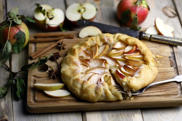 Galette with fresh apples on a wooden cutting board