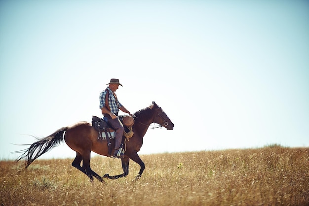 Photo galloping with freedom action shot of a man riding a horse in a field