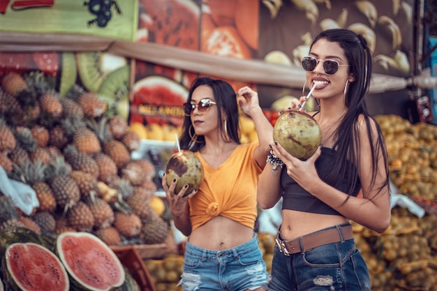 Gama/DF, Brazilië, 8 november 2021, twee meisjes die cola drinken voor een kraampje met tropisch fruit