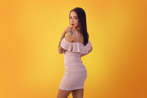 Gama,Distrito Federal, October 16, 2021,  young woman in short dress in sexy poses on a yellow background.