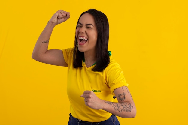 Gama federal district june 26 2022 young woman wearing the\
official uniform shirt of the brazilian soccer team at the 2022\
qatar cup in studio photo brazilian fan