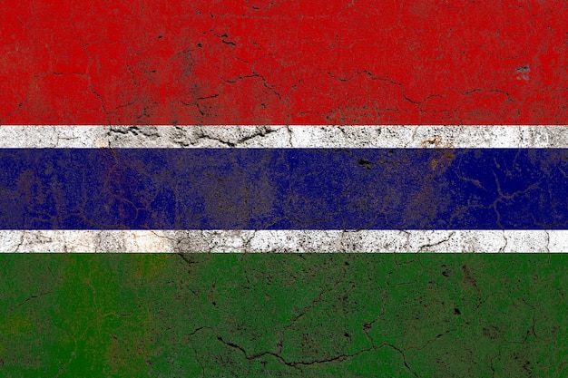 Gambia flag on a damaged old concrete wall surface