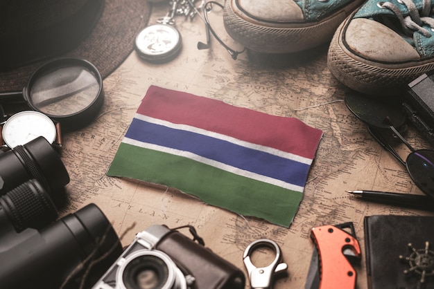 The Gambia Flag Between Traveler's Accessories on Old Vintage Map. Tourist Destination Concept.