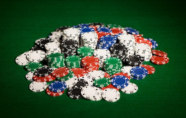 사진 도박, 재산, 게임 및 엔터테인먼트 개념 - 녹색 테이블 표면에 카지노 칩 클로즈업