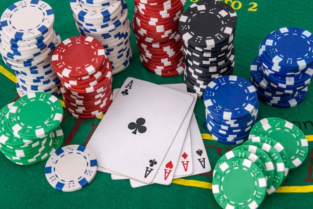 Gambling theme. Colorful casino chips on green poker table close up