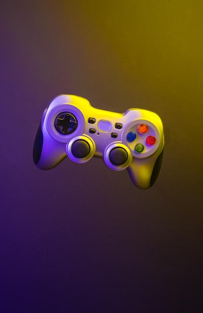 Game console controller levitating against a multicolored illuminated background International day of videogames Video game Esports