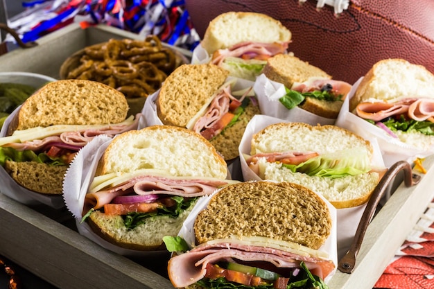 Game day football party table with sub sandwich and\
snacks.