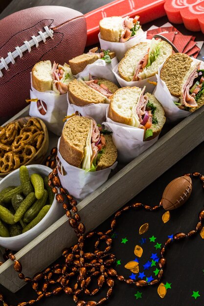 Game day football party table with  sub sandwich and snacks.