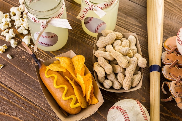 Photo game day traditional snacks included corndogs and salted peanuts on a wood board.