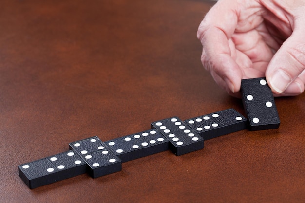 Game of dominoes on leather table