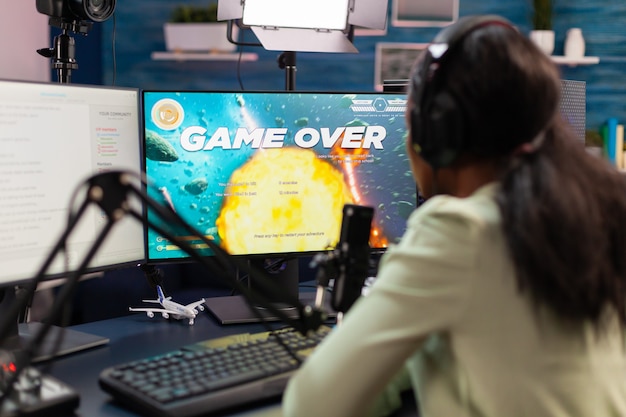 Game over for esport african strategy player during tournament live. Professional gamer streaming online video games with new graphics on powerful computer.