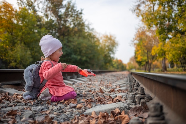 Il gioco dei non giocattoli, la bambina carina gioca sui binari della ferrovia abbandonati