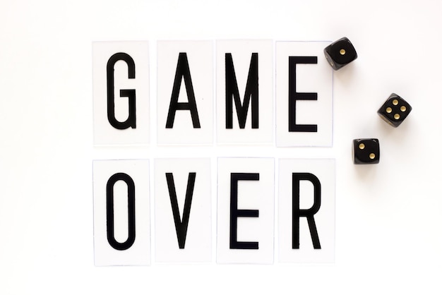 GAME OVER tekst met gaming dobbelstenen op witte achtergrond bovenaanzicht