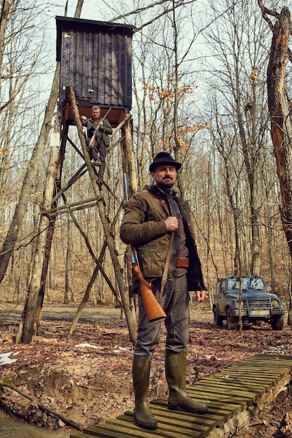 Game ranger with gun at the feeding spot for wild animals