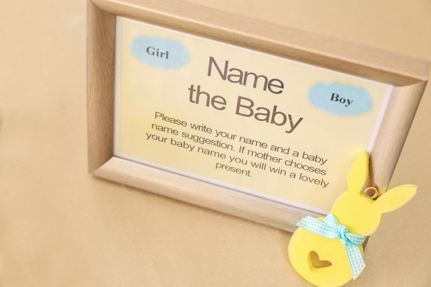 Photo game for suggestion of baby name on table at shower party