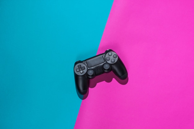Gamepads on a colored paper. Top view. Minimalism. Hard light shade