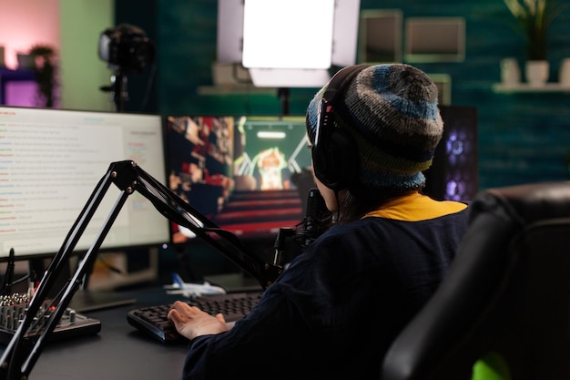 Gamer doing online live stream with video games. Woman using gameplay on computer, streaming and looking at monitor with chat. Person broadcasting and playing games with microphone.