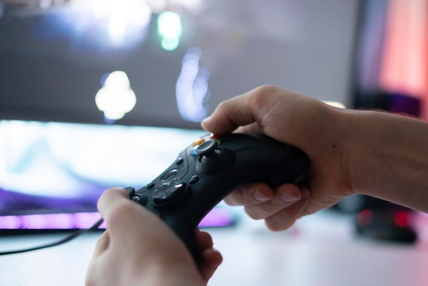 Un giocatore che tiene in mano un controller del gamepad e gioca al videogioco