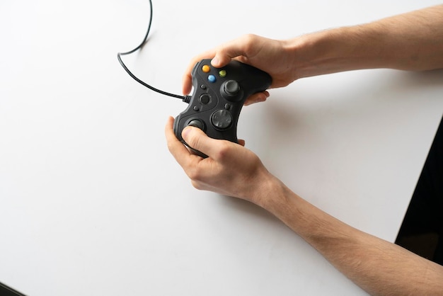 A gamer holding a gamepad controller and playing the video game