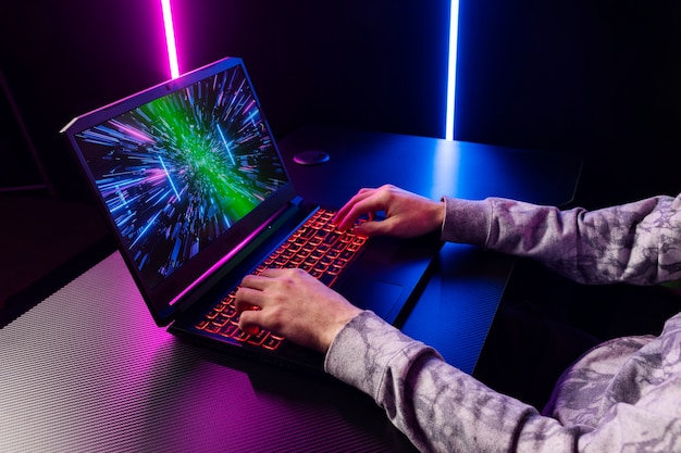 gamer playing on laptop side view