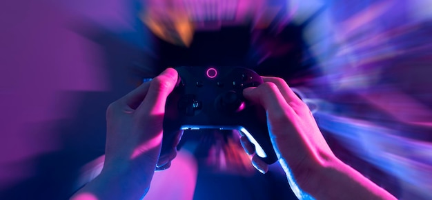 Photo gamer playing the online game with joystick controller in neon glow dark cyberpunk room gaming and esports challenge tournament streaming streamer with analog device in living house