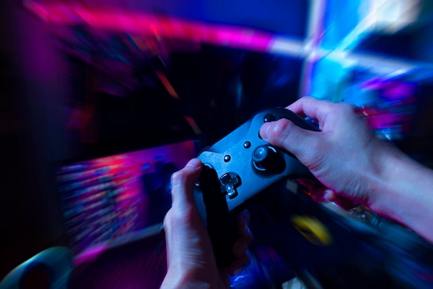 Gaming controller in hands, playing games and online streaming with gamer  competition and esports. Video game tech, streamer person in dark room and  play tournament with joystick and keyboard Stock Photo