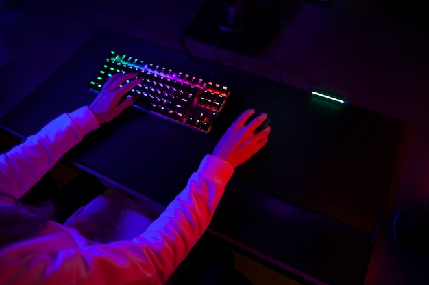 Gamer's hands on the keyboard and mouse a person uses a computer top view closeup