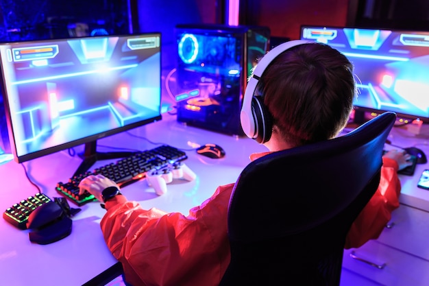Foto gamer speelt online game op pc in een donkere kamer.