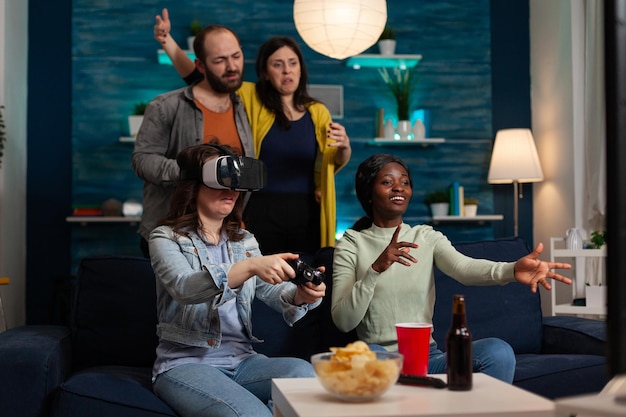 Gamer-vrouw met een virtual reality-headset met een gamecontroller die videogames speelt en de online concurrentie verliest. Groep multi-etnische vrienden die graag samen rondhangen en leuke activiteiten maken