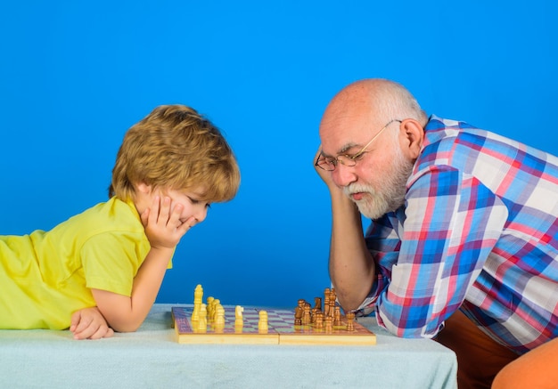 어린이를 위한 게임 및 활동 체크메이트 어린 소년은 체스 게임 할아버지를 생각하거나 계획합니다.